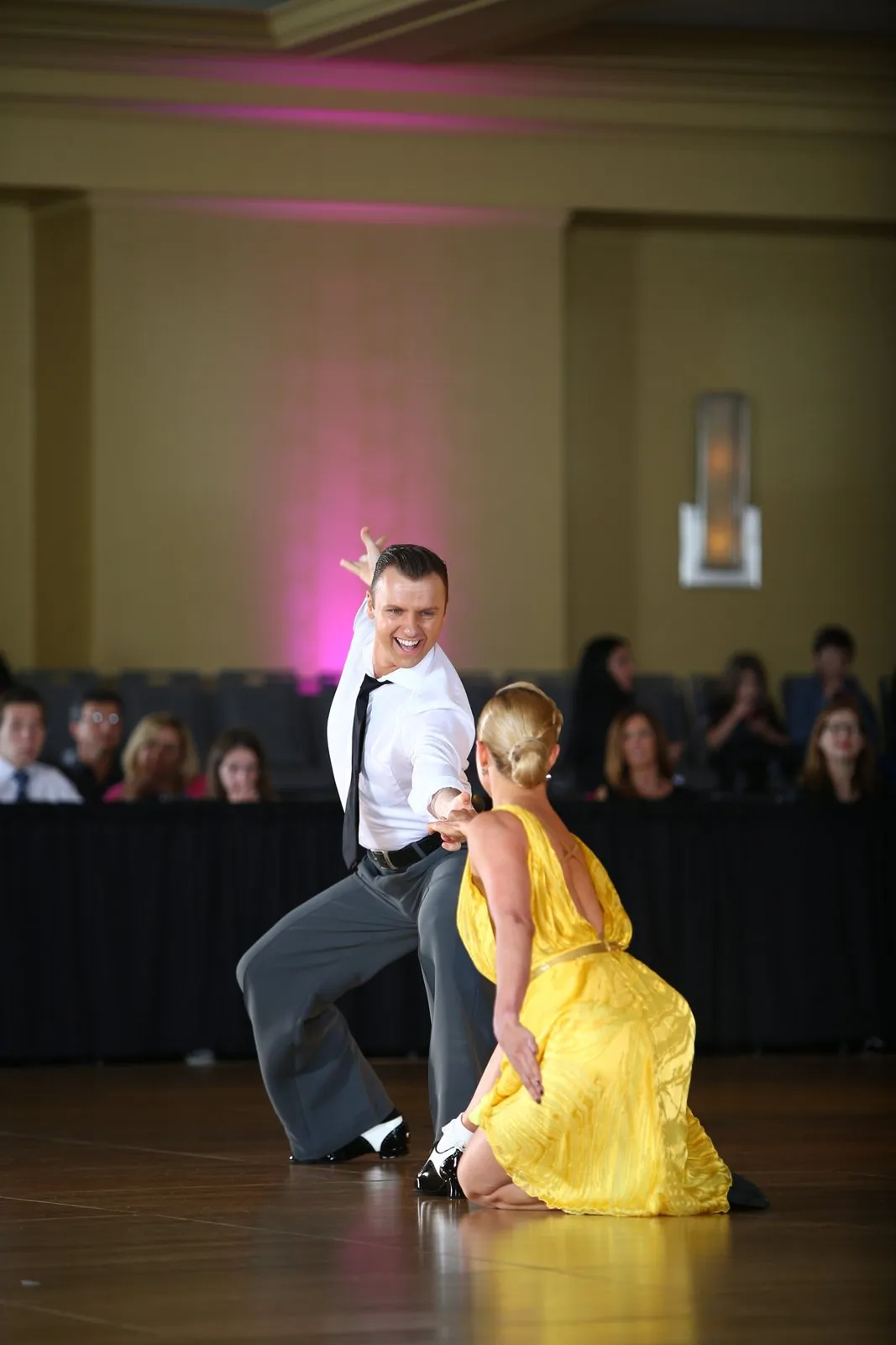 Slawek and Denise in a playful show-dance moment, Denise in a yellow dress